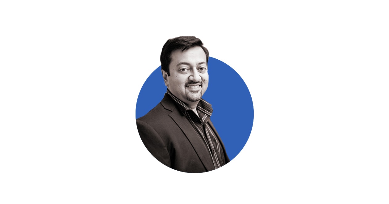 photo of Kamal with blue circle background, man with dark hair and a mustache