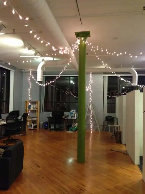 picture of office with green pole and christmas style white lights hanging from pole