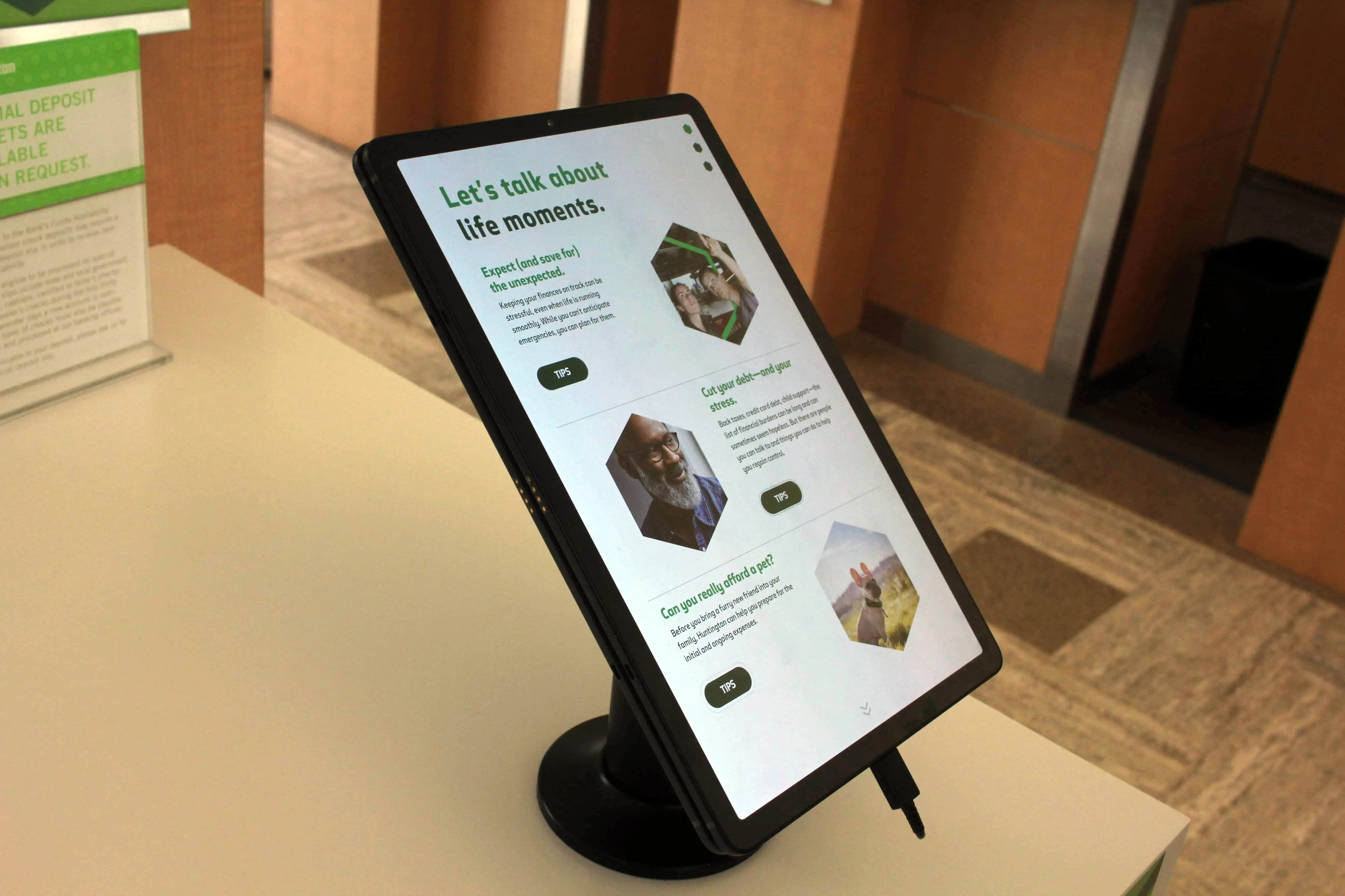 Image of a tablet mounted on a desk with Huntington Bank tips listed on the screen with touchscreen capabilities