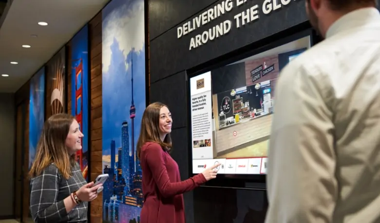 image of two women using a large touch screen and smiling