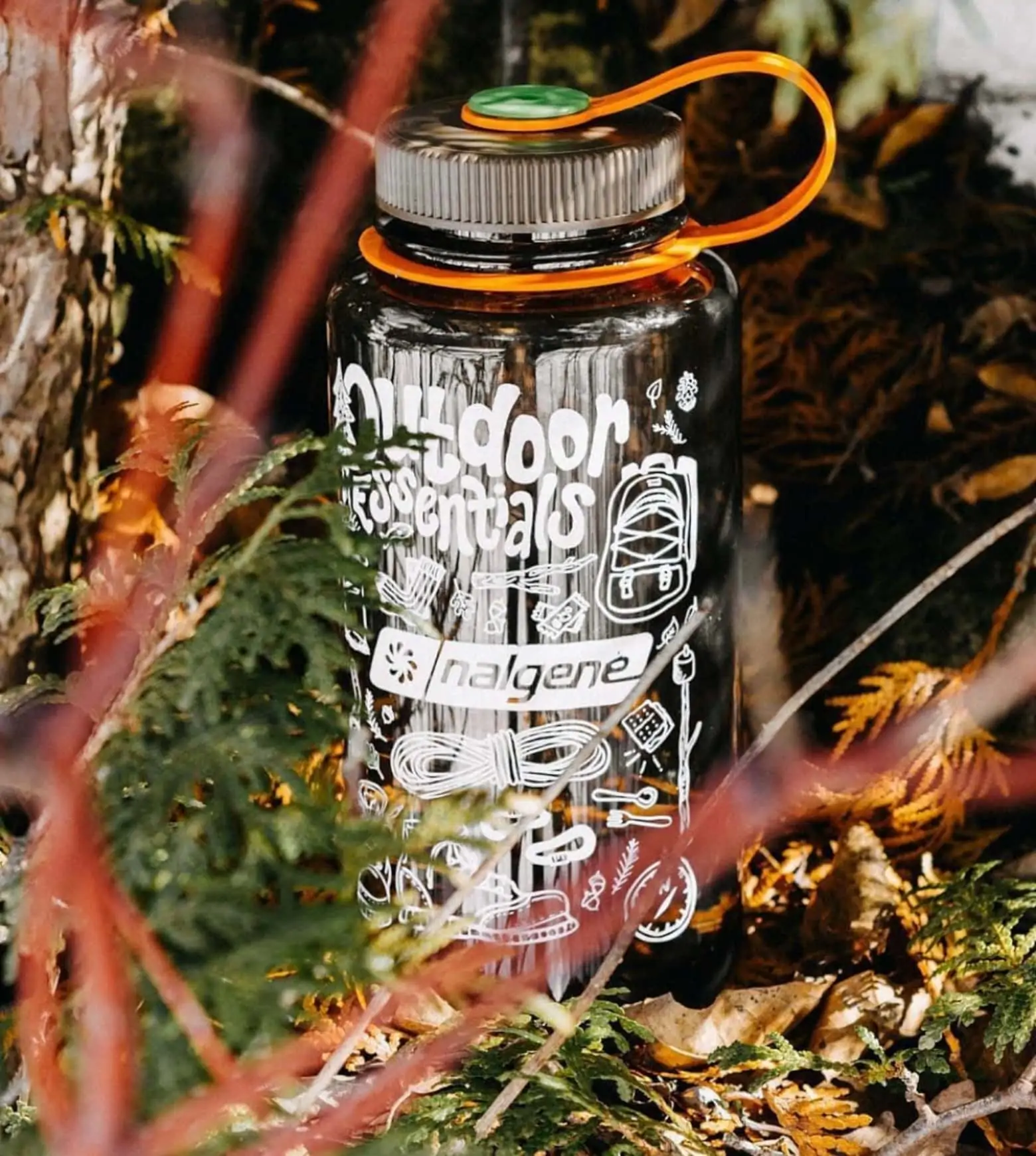 image of a Nalgene bottle sitting on the ground amongst leaves and trees