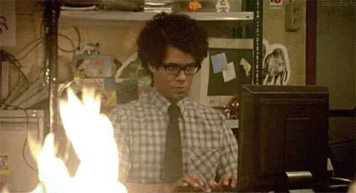 Gif of Moss from "It Crowd" sitting at his desk which is on fire