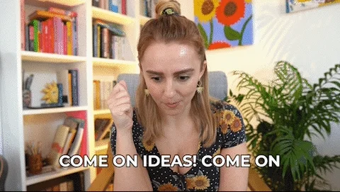 A woman sits in a home office nodding and saying "come on ideas. come on."